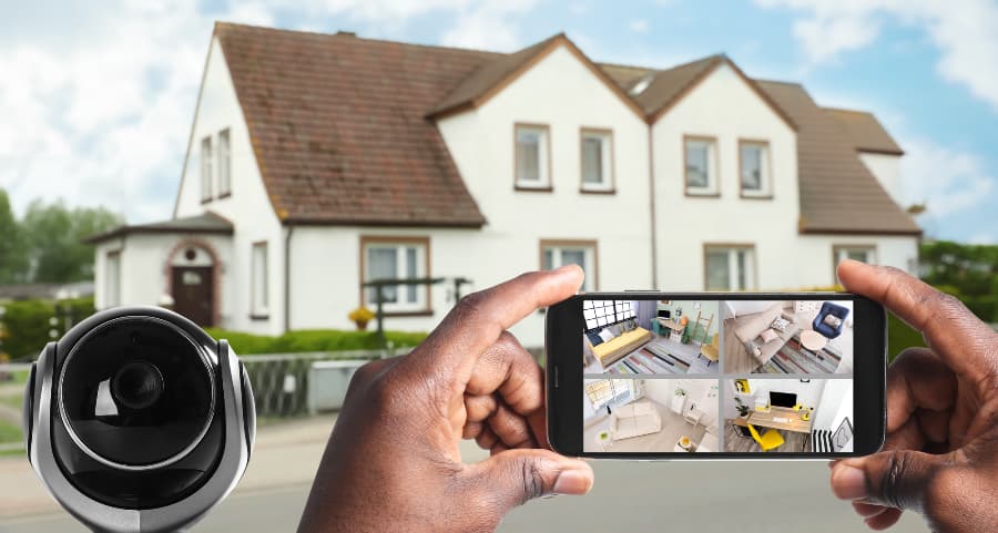 Man holding phone and looking at streams from surveillance cameras